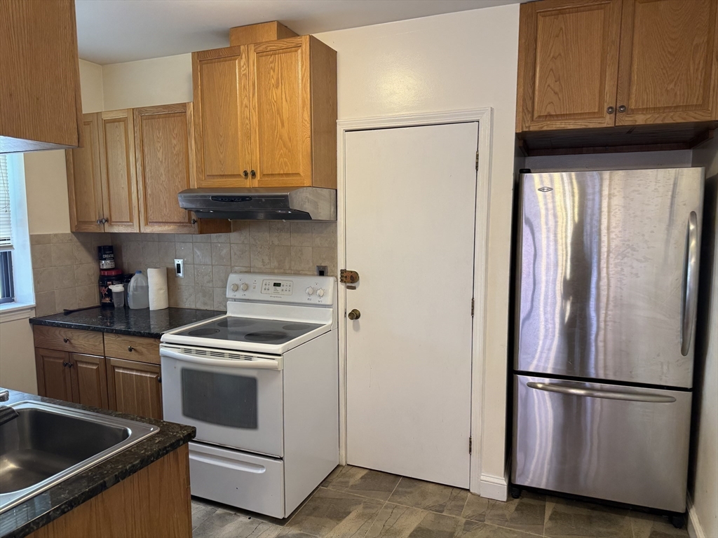 313 Summit Avenue, Unit 5 Boston, MA 02135 - Photo 6 of 13 a kitchen with a refrigerator sink and cabinets