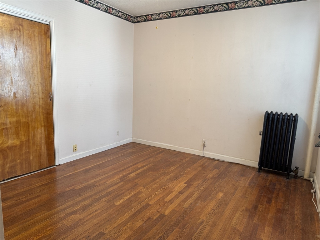 313 Summit Avenue, Unit 5 Boston, MA 02135 - Photo 8 of 13 a view of an empty room with wooden floor