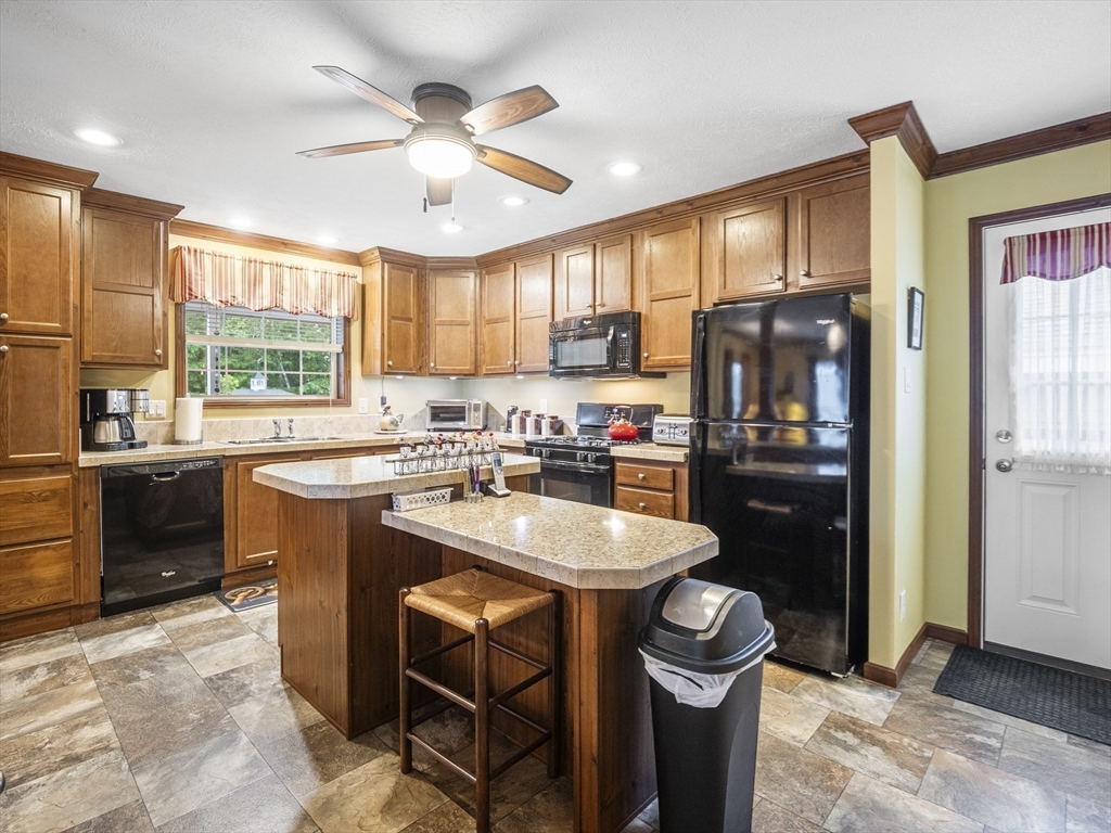 53 Ruby Road Gardner, MA 01440 - Photo 7 of 40 a kitchen with stainless steel appliances granite countertop a stove a refrigerator a sink a dining table and chairs with wooden floor