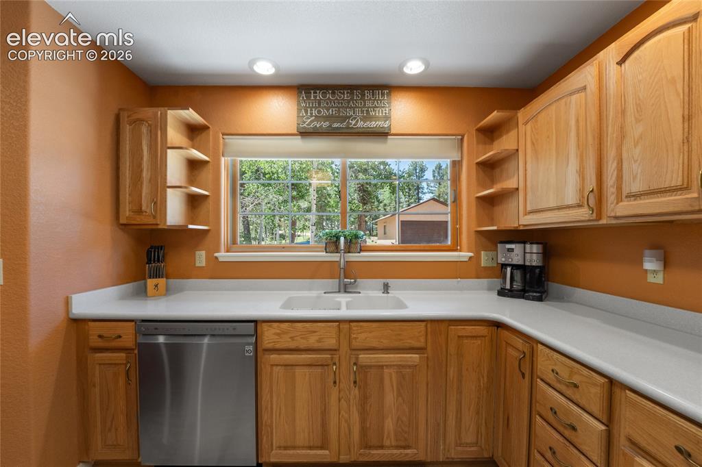 657 Spring Valley Drive Divide, CO 80814 - Photo 19 of 43 U-shaped kitchen featuring light wood cabinetry, white countertops, and a stainless steel dishwasher