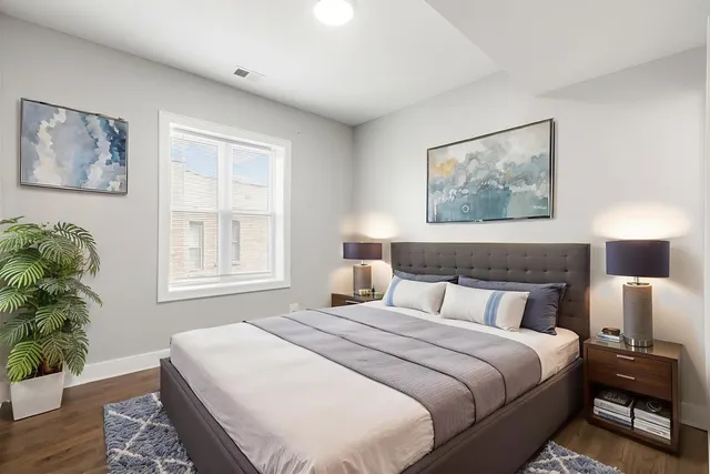 a bedroom with bed and paintings on the wall