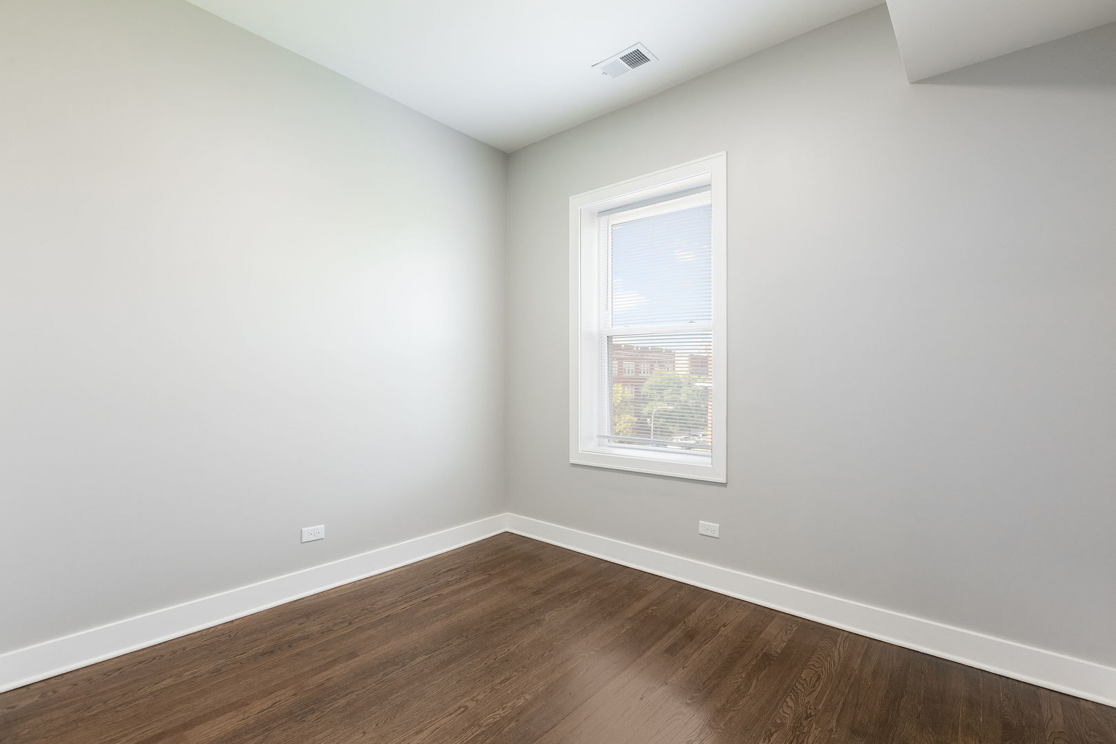 7753 South Morgan Street, Unit 3 Chicago, IL 60620 - Photo 6 of 13 an empty room with wooden floor and windows