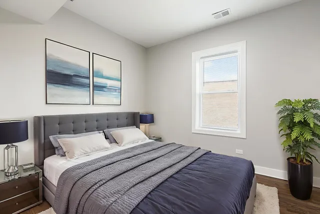 a bedroom with a bed and a potted plant