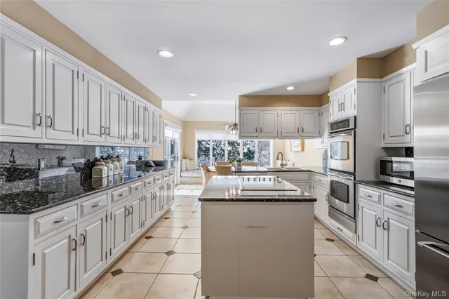 a spacious bedroom with a bed a dresser and next to a window
