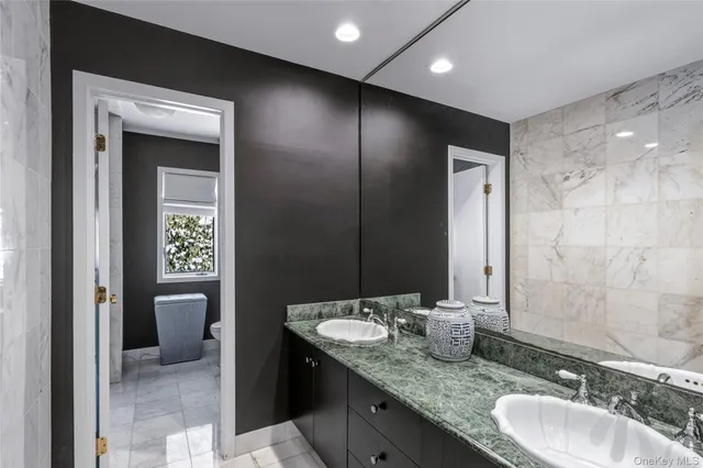 a bathroom with a granite countertop shower a toilet and a shower
