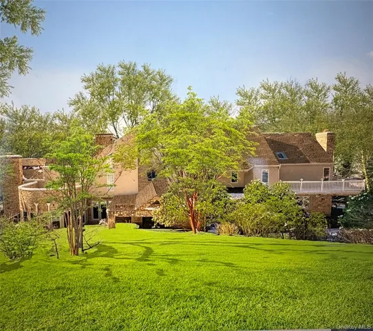a living room with furniture large windows and wooden floor