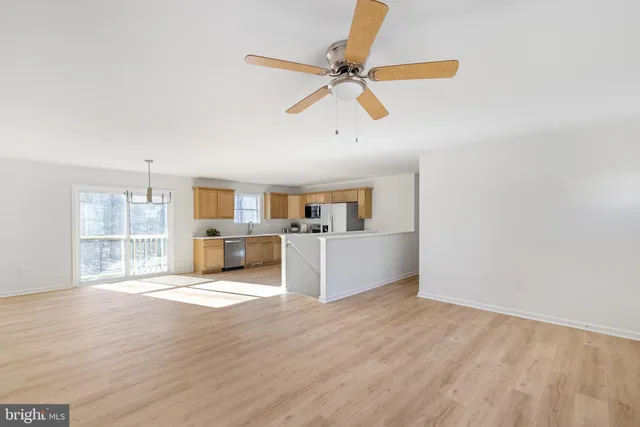 a view of a livingroom with wooden floor and a ceiling fan