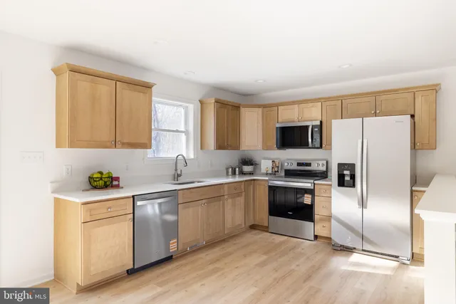 a kitchen with a sink cabinets stainless steel appliances and a window