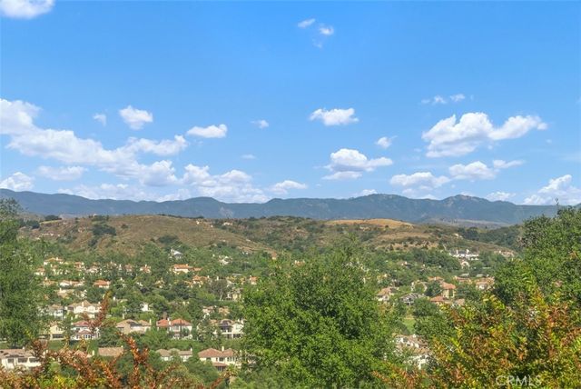 a view of patio with chairs and table under an umbrella