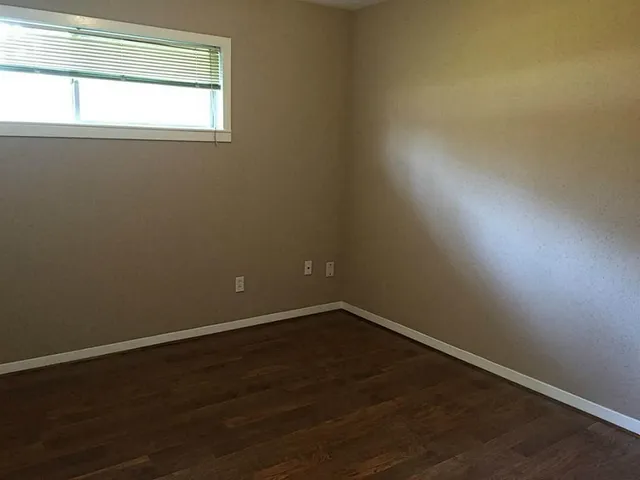 a view of a small space with wooden floor and a window