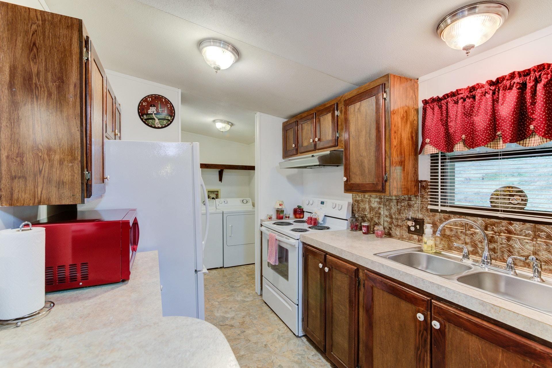 1577 Carroll Road Goodview, VA 24095 - Photo 11 of 40 a kitchen with a sink stove and cabinets