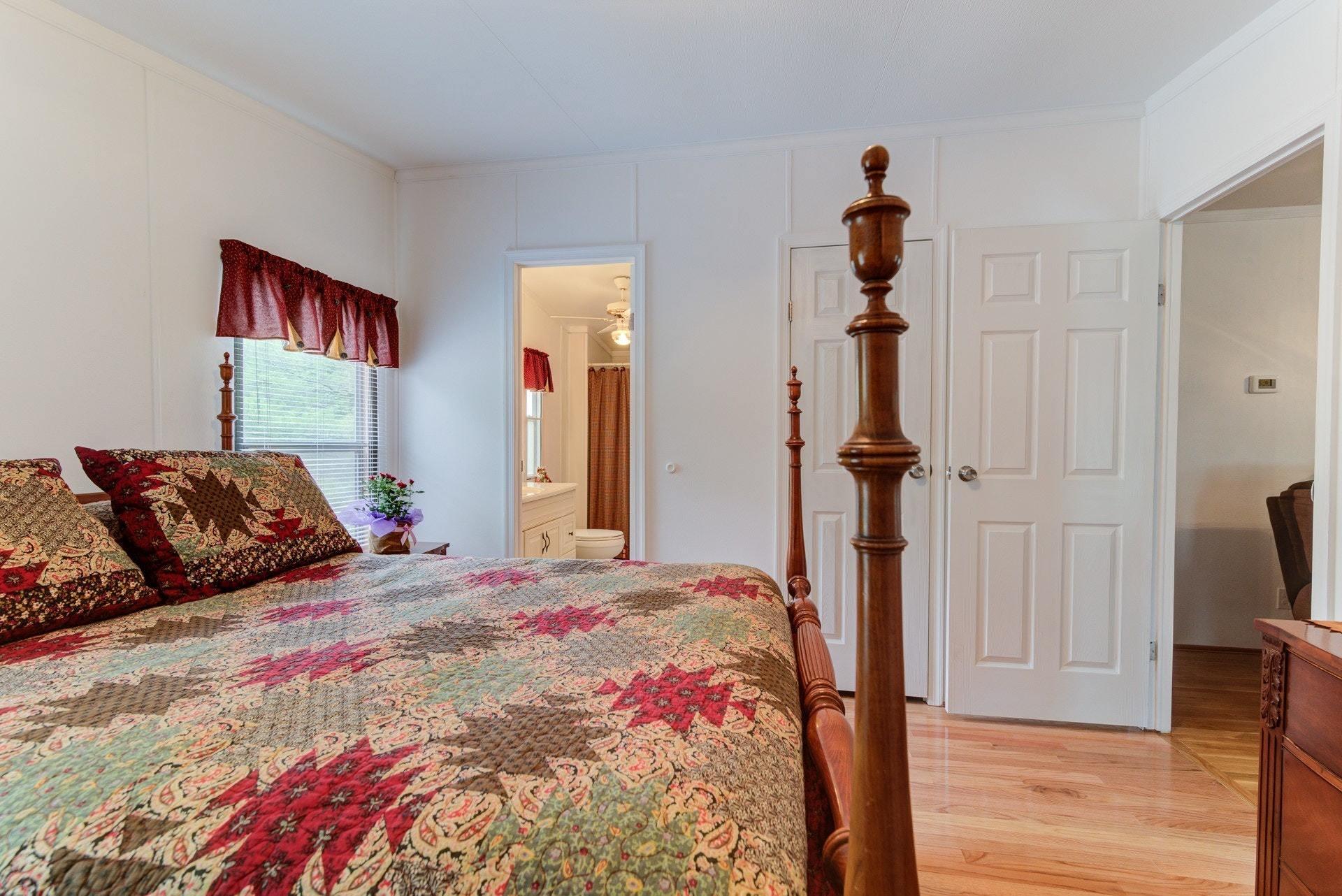 1577 Carroll Road Goodview, VA 24095 - Photo 21 of 40 a bedroom with a bed and a chandelier