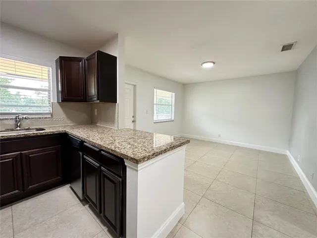 a kitchen with granite countertop a sink and a stove