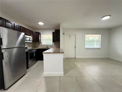 a kitchen with stainless steel appliances granite countertop a refrigerator a sink a stove a microwave and island