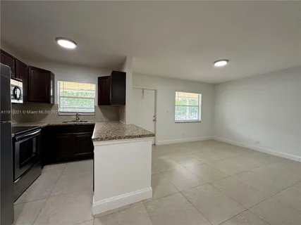 a kitchen with granite countertop a stove top oven sink and cabinets
