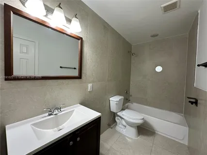 a bathroom with a sink mirror and toilet