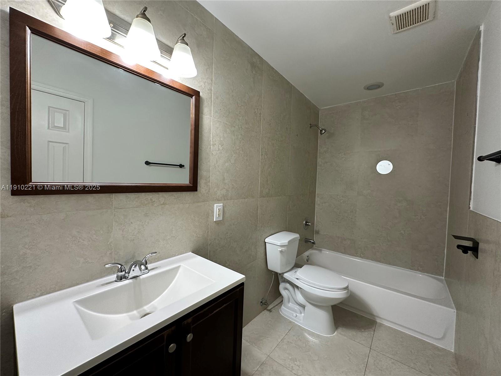2640 Northeast 8th Avenue, Unit 13 Wilton Manors, FL 33334 - Photo 19 of 34 a bathroom with a sink mirror and toilet