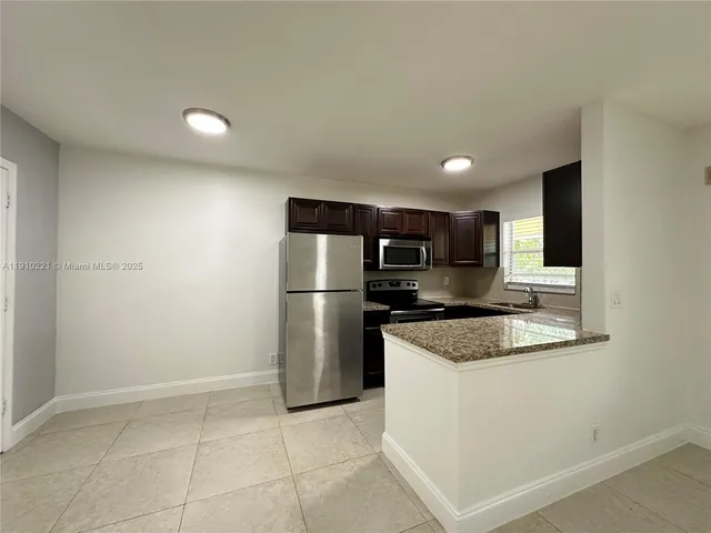 a kitchen with stainless steel appliances granite countertop a refrigerator sink and stove