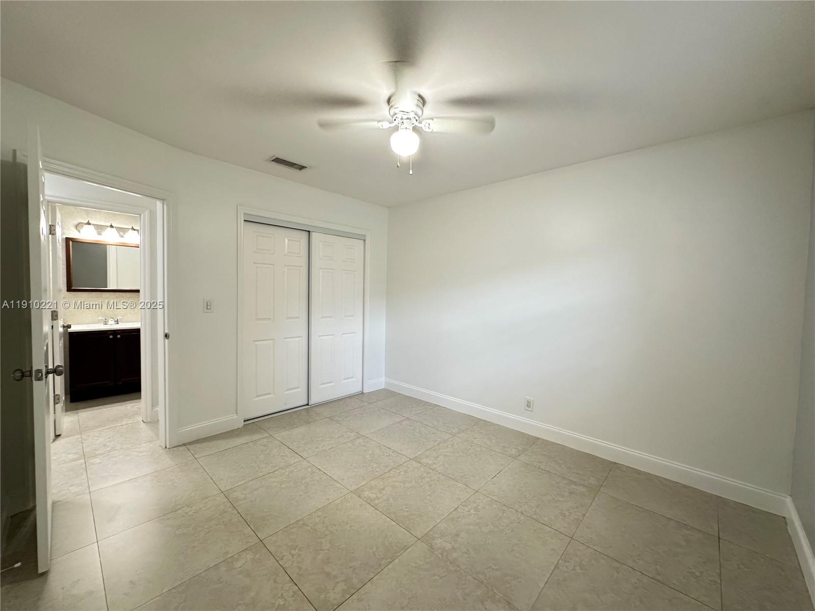 2640 Northeast 8th Avenue, Unit 13 Wilton Manors, FL 33334 - Photo 24 of 34 an empty room with closet and a ceiling fan