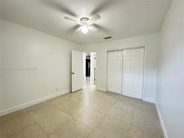 an empty room with fan and entrance