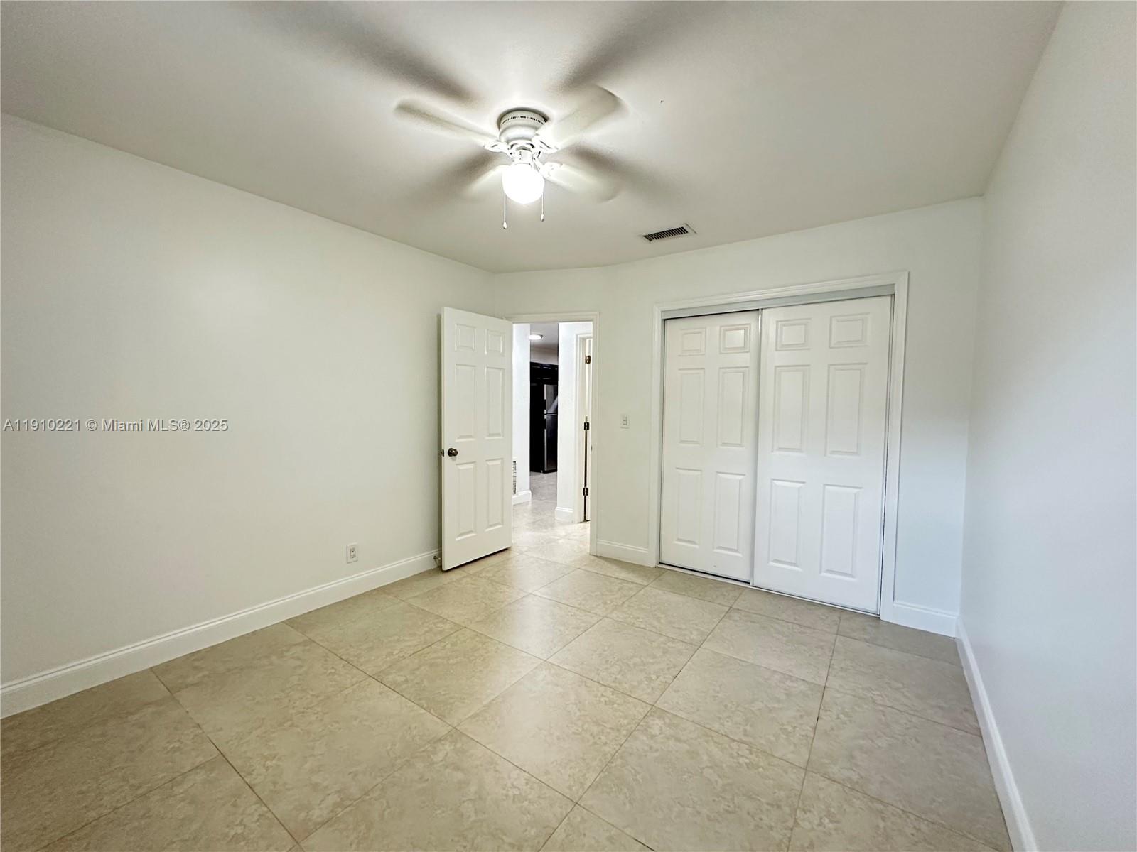 2640 Northeast 8th Avenue, Unit 13 Wilton Manors, FL 33334 - Photo 25 of 34 an empty room with fan and entrance