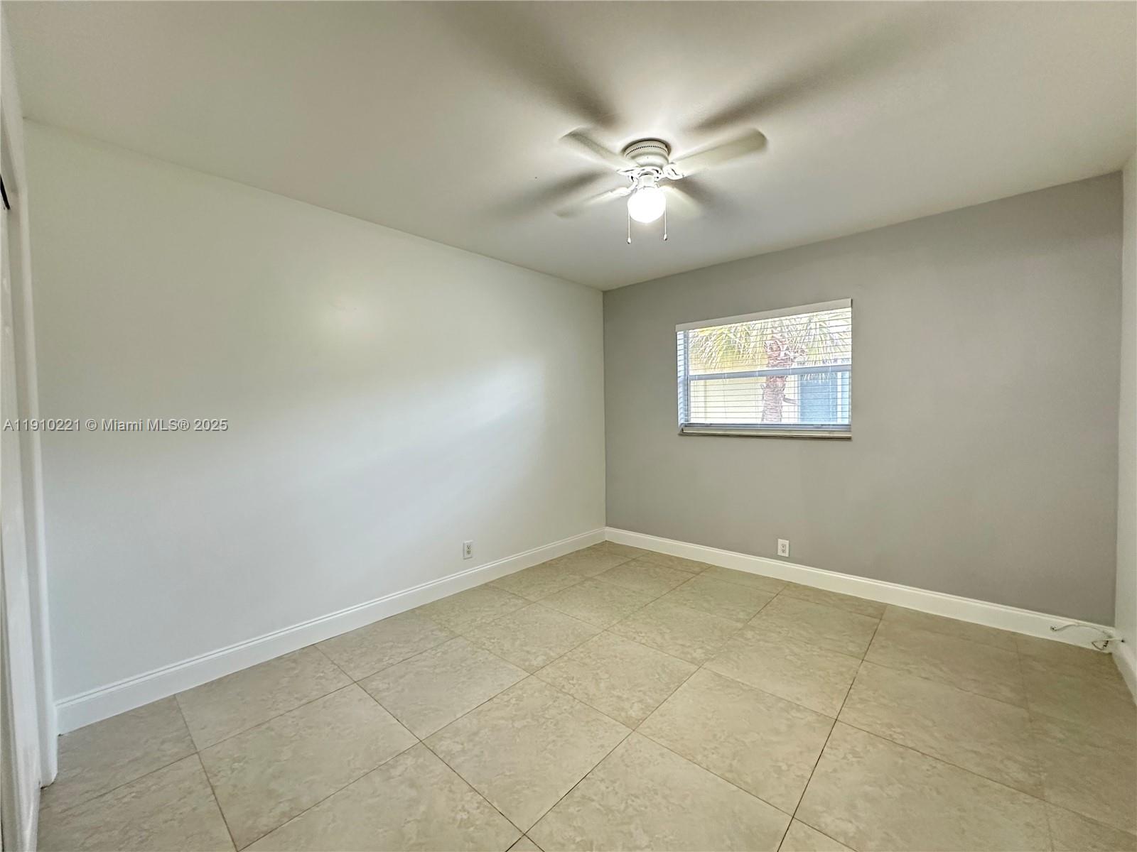 2640 Northeast 8th Avenue, Unit 13 Wilton Manors, FL 33334 - Photo 26 of 34 an empty room with windows and fan