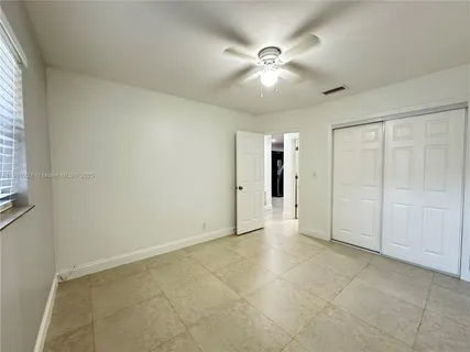an empty room with fan and windows