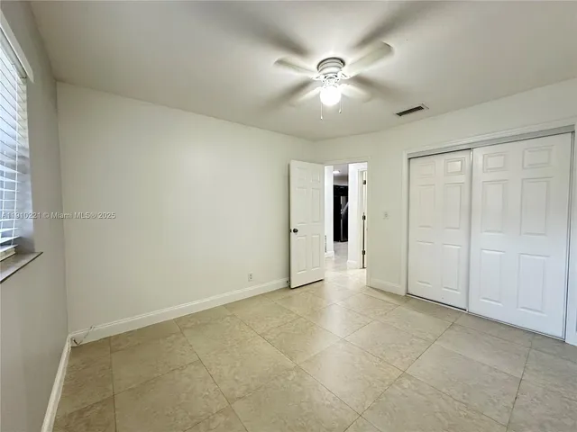 an empty room with fan and windows