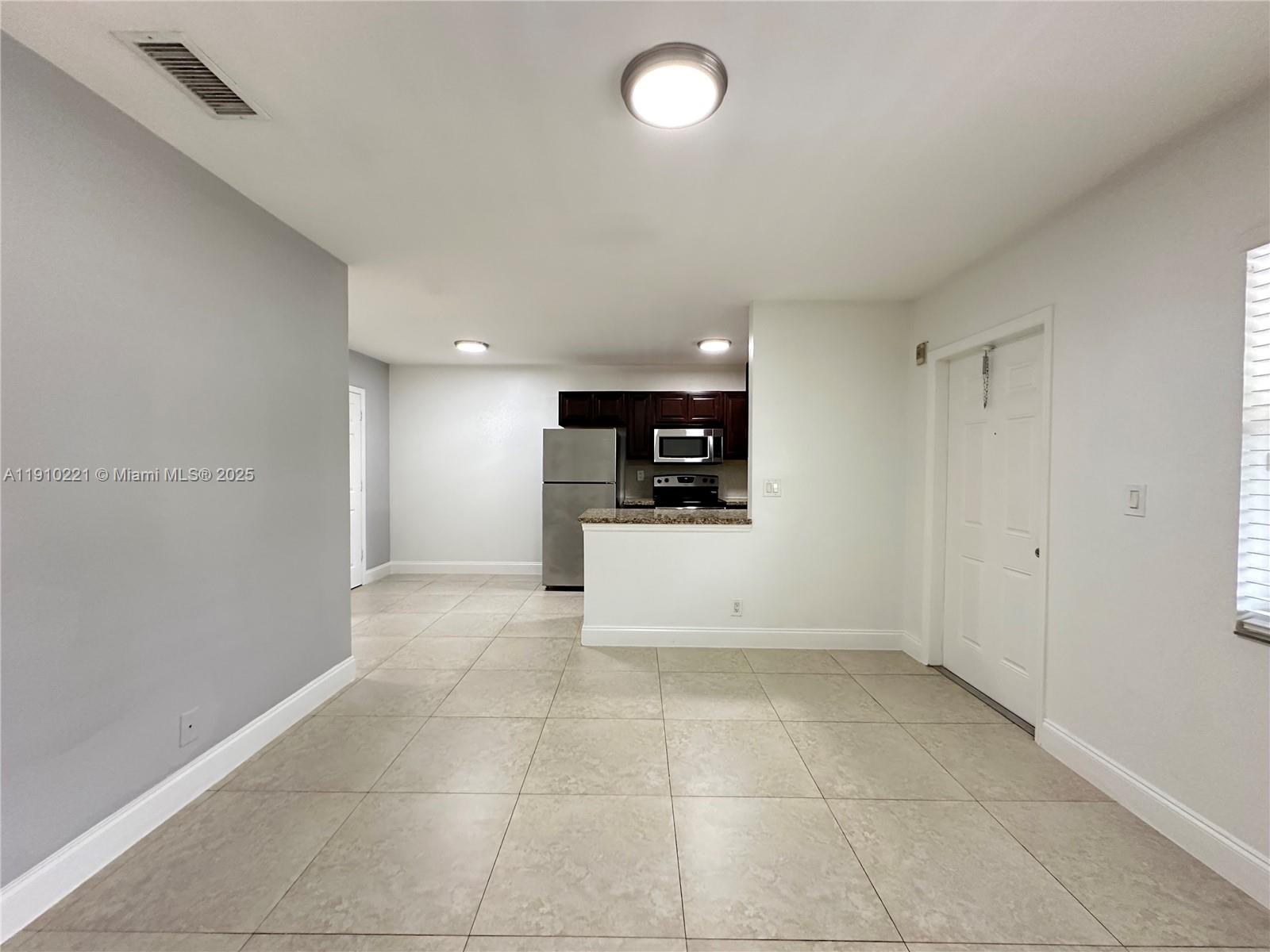 2640 Northeast 8th Avenue, Unit 13 Wilton Manors, FL 33334 - Photo 3 of 34 a view of a kitchen with a sink and a stove top oven