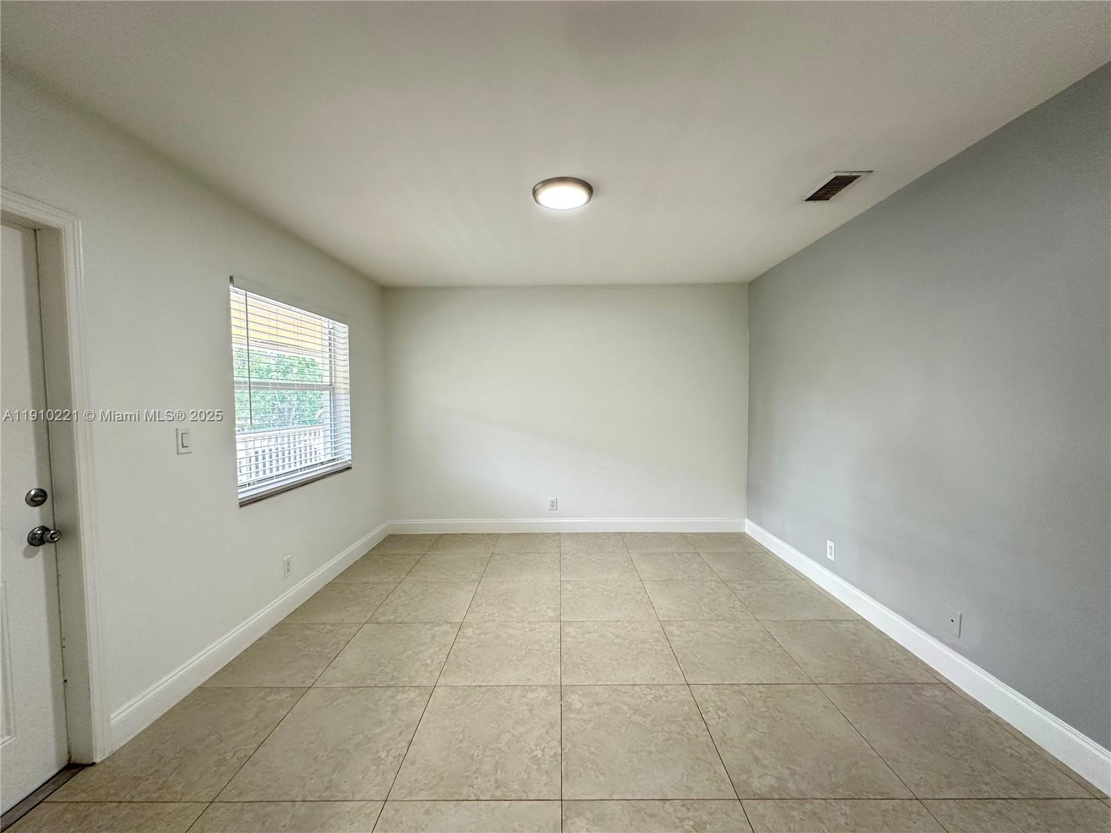 2640 Northeast 8th Avenue, Unit 13 Wilton Manors, FL 33334 - Photo 8 of 34 a view of an empty room with a window