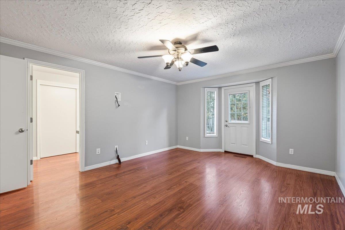 11457 Alejandro Street Boise, ID 83709 - Photo 17 of 42 Entryway featuring a ceiling fan, wood finished floors, crown molding, and a textured ceiling