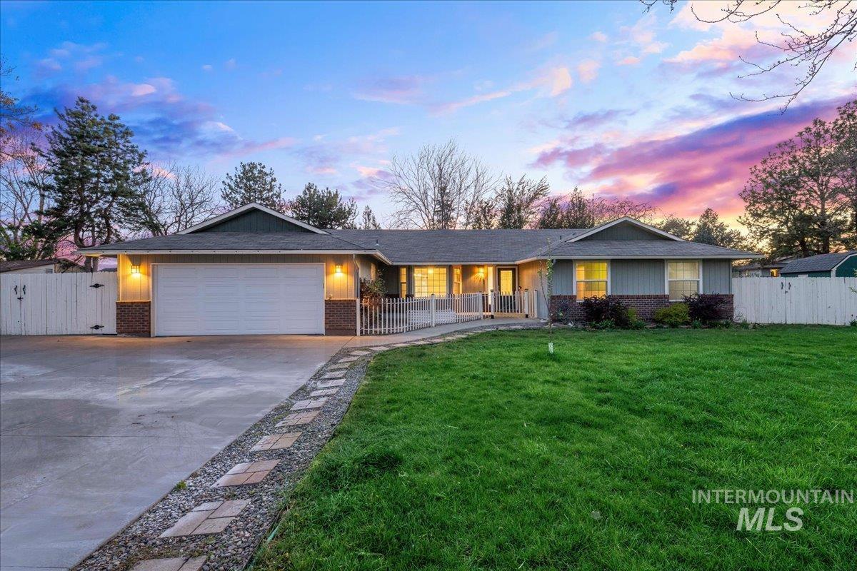 11457 Alejandro Street Boise, ID 83709 - Photo 2 of 42 Single story home featuring a gate, brick siding, an attached garage, and concrete driveway