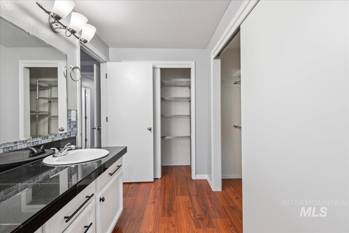 11457 Alejandro Street Boise, ID 83709 - Photo 22 of 42 Bathroom with vanity, dark wood-type flooring, and a walk in closet