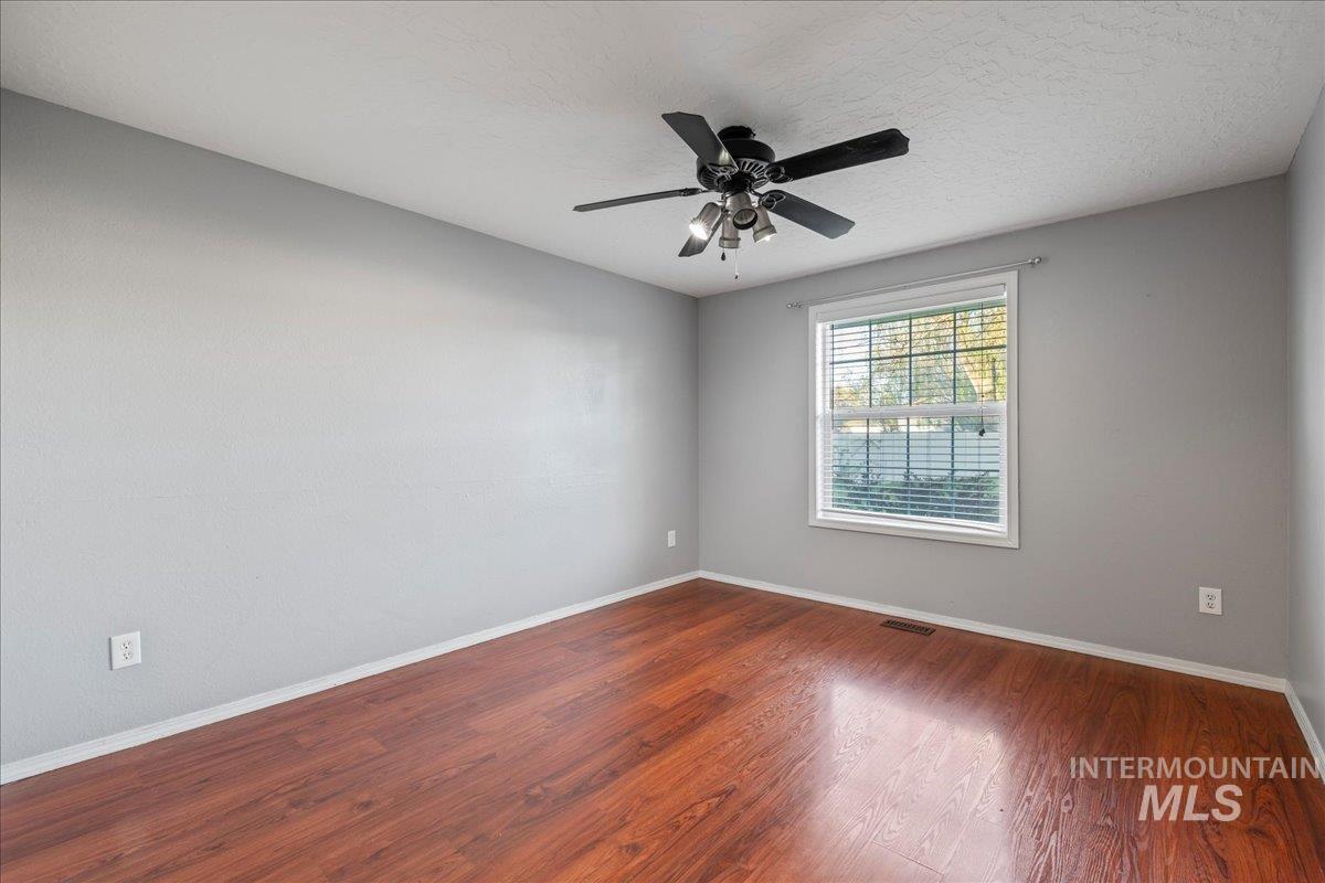 11457 Alejandro Street Boise, ID 83709 - Photo 24 of 42 Empty room featuring wood finished floors and a ceiling fan