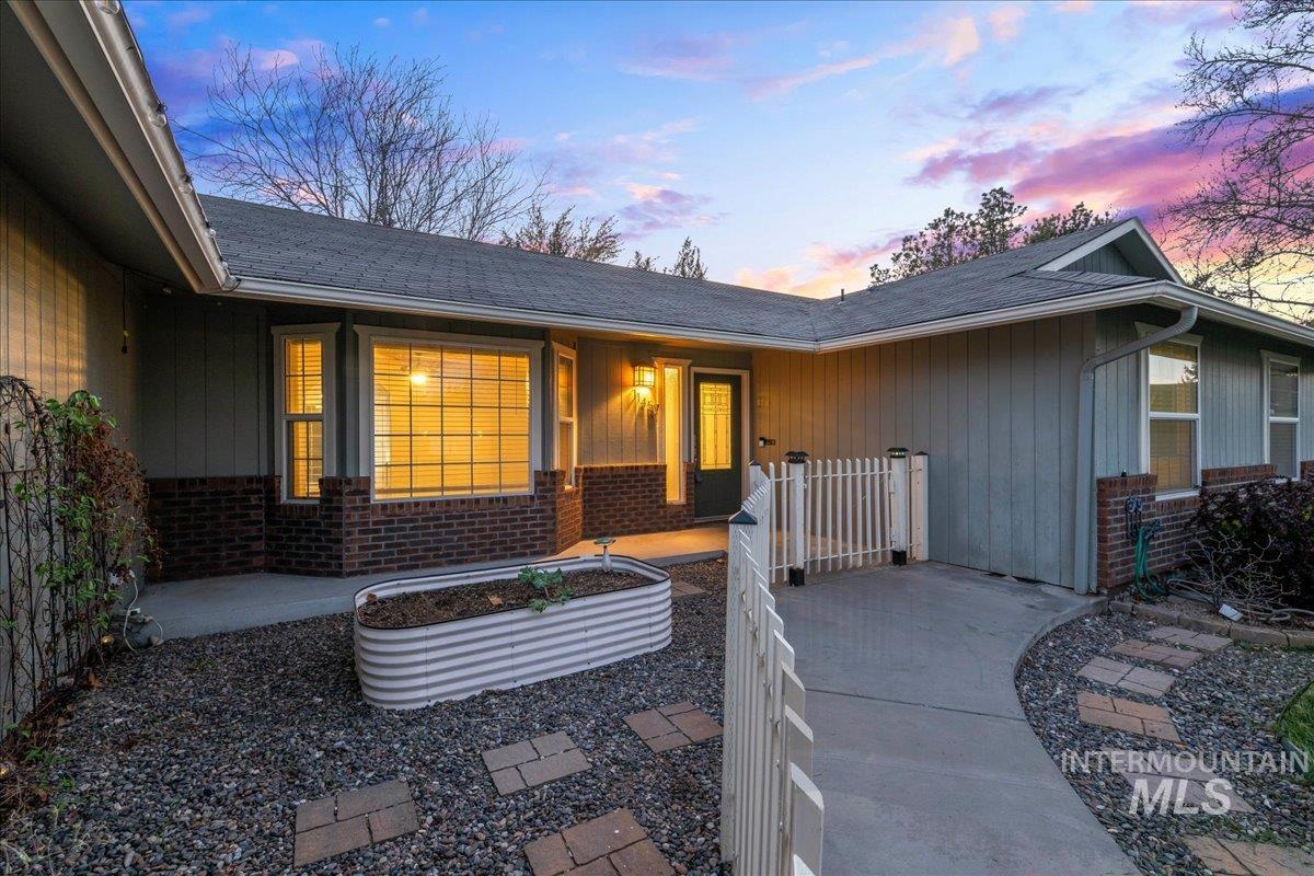 11457 Alejandro Street Boise, ID 83709 - Photo 3 of 42 Doorway to property featuring brick siding and roof with shingles
