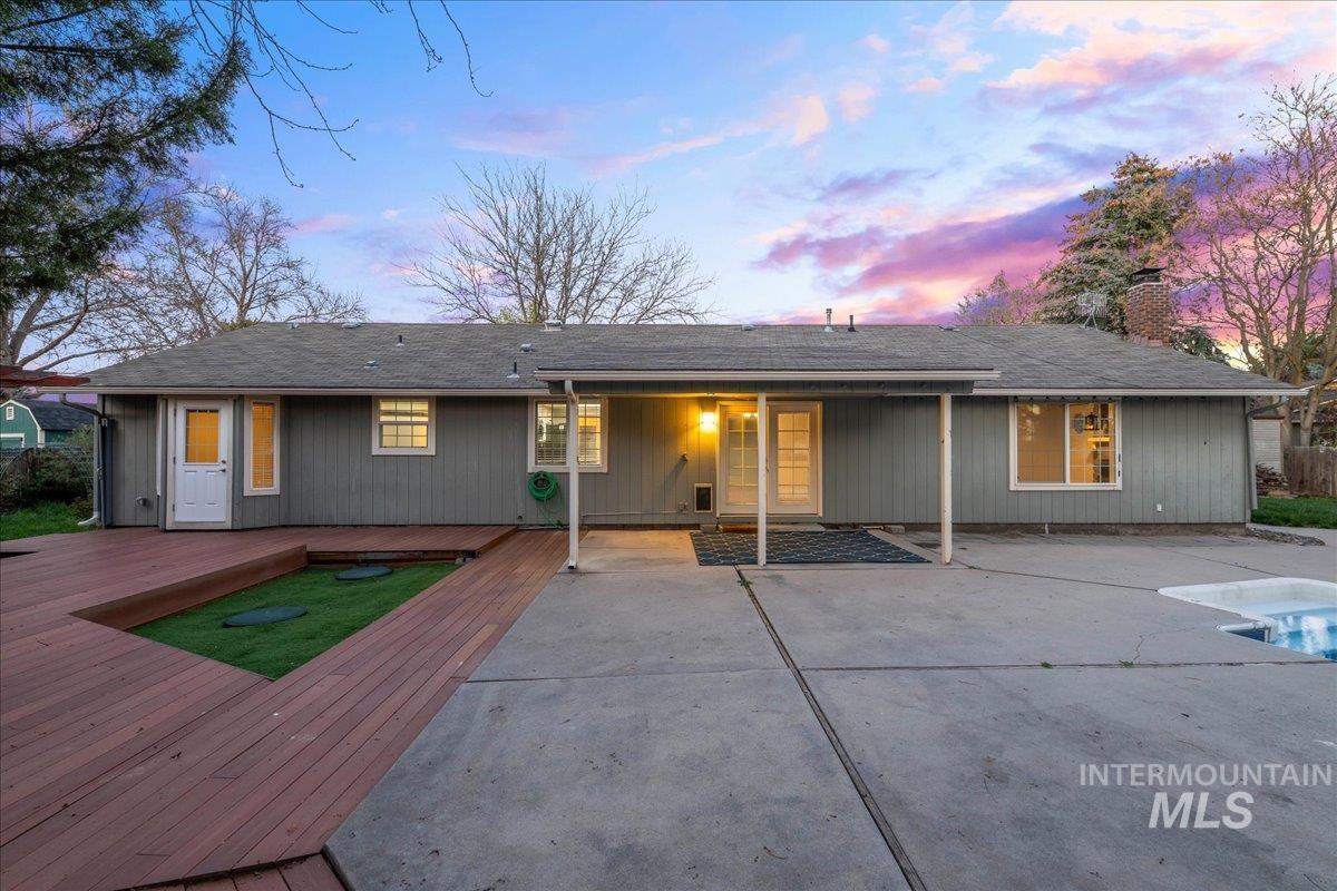 11457 Alejandro Street Boise, ID 83709 - Photo 30 of 42 Rear view of house with a wooden deck, an outdoor pool, a patio, and a chimney
