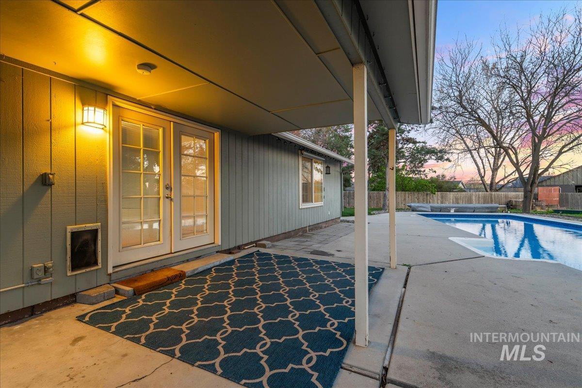 11457 Alejandro Street Boise, ID 83709 - Photo 31 of 42 Pool at dusk featuring french doors, a patio, and a fenced backyard