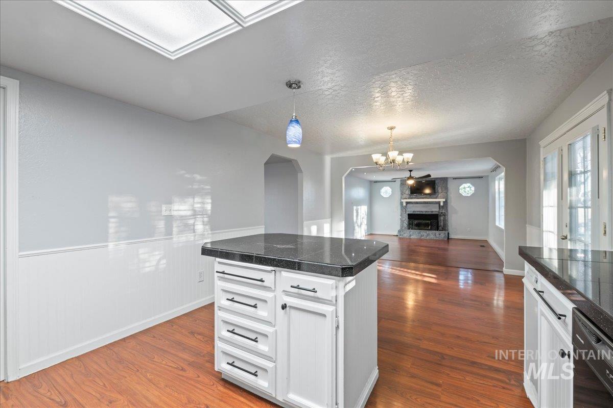 11457 Alejandro Street Boise, ID 83709 - Photo 42 of 42 Kitchen with tile counters, a textured ceiling, dark wood-type flooring, suspended lighting, and open floor plan
