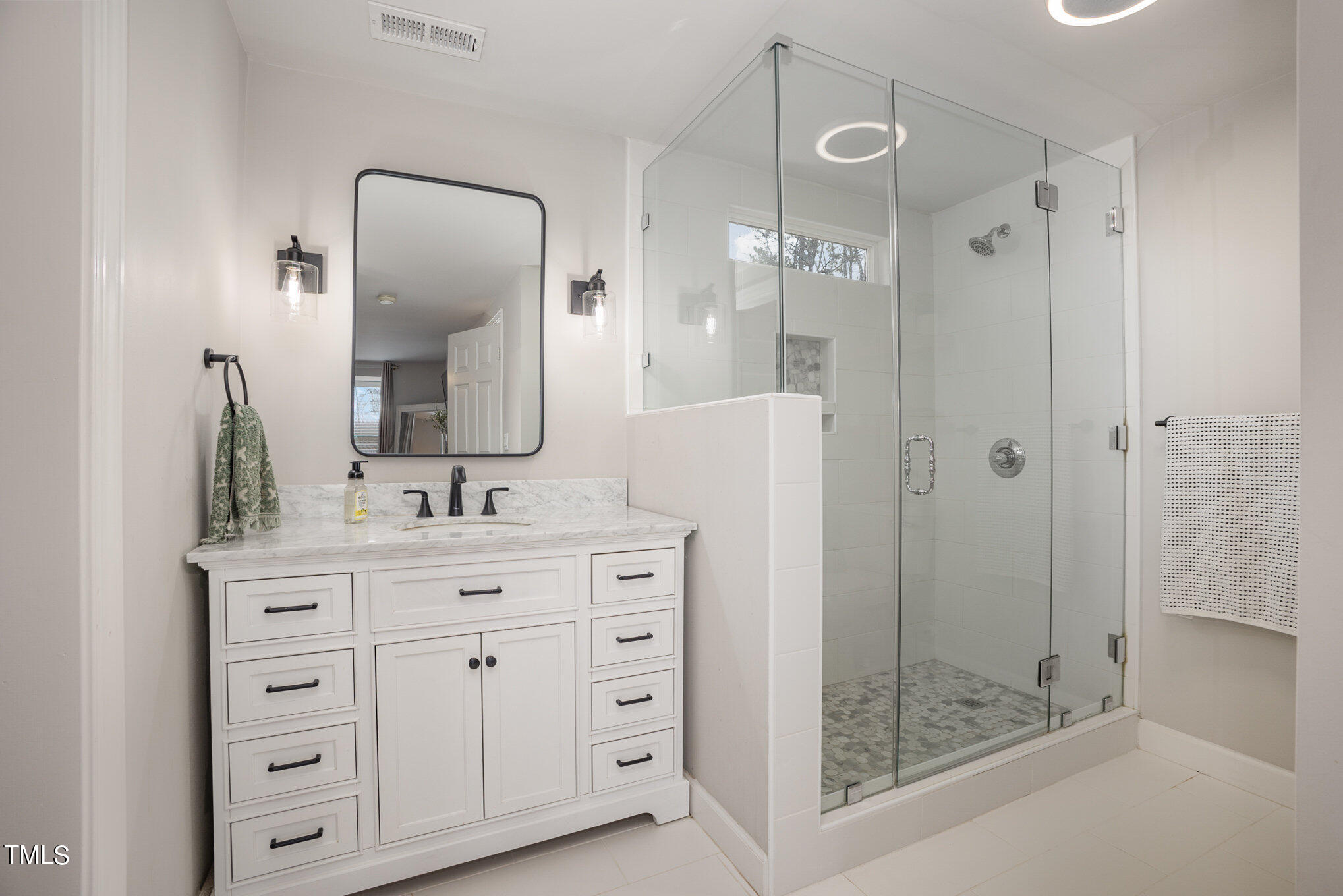 4324 Hickory Ridge Drive Raleigh, NC 27609 - Photo 21 of 34 a bathroom with a shower a mirror and a sink