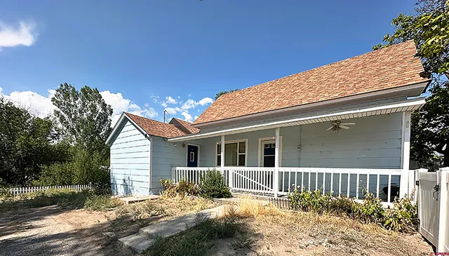 a view of a house with a large window and wooden fence