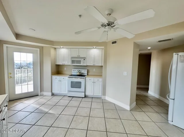 a kitchen with stainless steel appliances kitchen island granite countertop a refrigerator and a sink