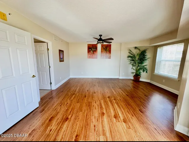 a view of a livingroom with wooden floor and a ceiling fan
