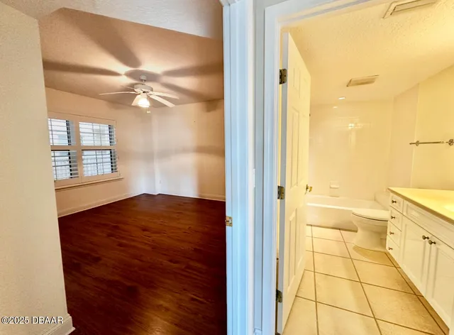 a bathroom with a granite countertop sink a toilet and bathtub
