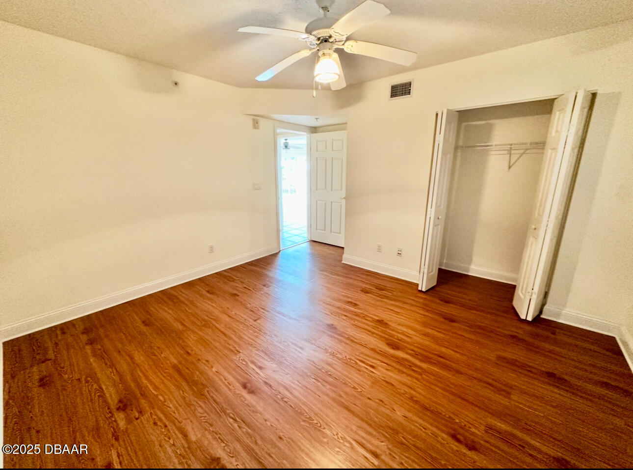 4670 Links Village Drive, Unit C404 Ponce Inlet, FL 32127 - Photo 24 of 41 an empty room with wooden floor and a ceiling fan