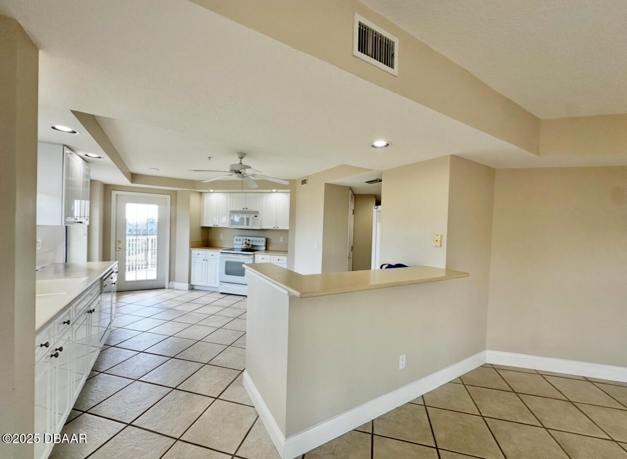4670 Links Village Drive, Unit C404 Ponce Inlet, FL 32127 - Photo 7 of 41 a large white kitchen with a stove a sink dishwasher and a refrigerator with white cabinets