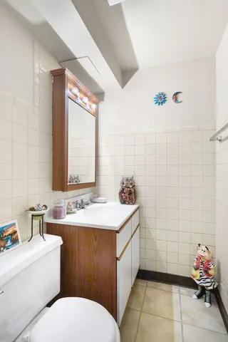 a bathroom with a sink toilet and a mirror