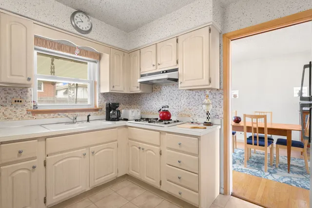 a kitchen with white cabinets and white appliances
