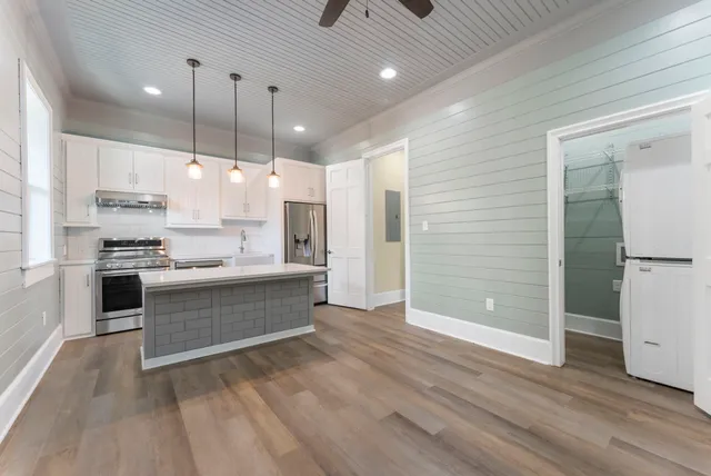 a view of kitchen with stainless steel appliances granite countertop a stove and a refrigerator