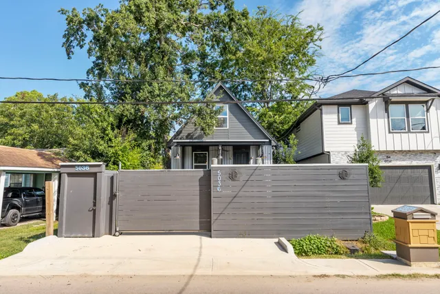 a front view of a house with a tree