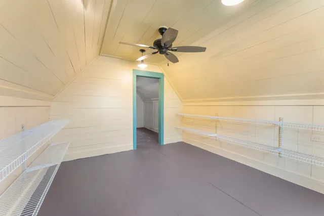a view of a hallway with wooden floor and cabinet